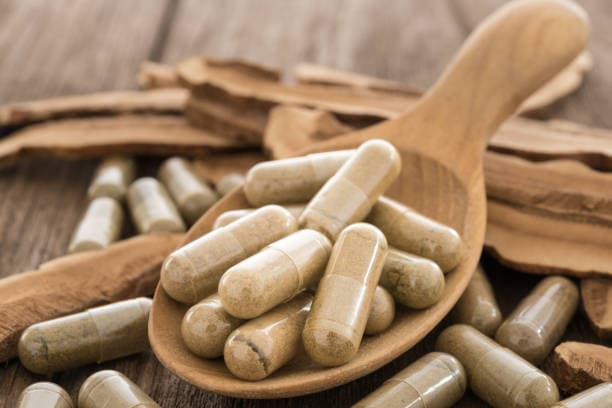 Probiotic capsules on wooden spoon