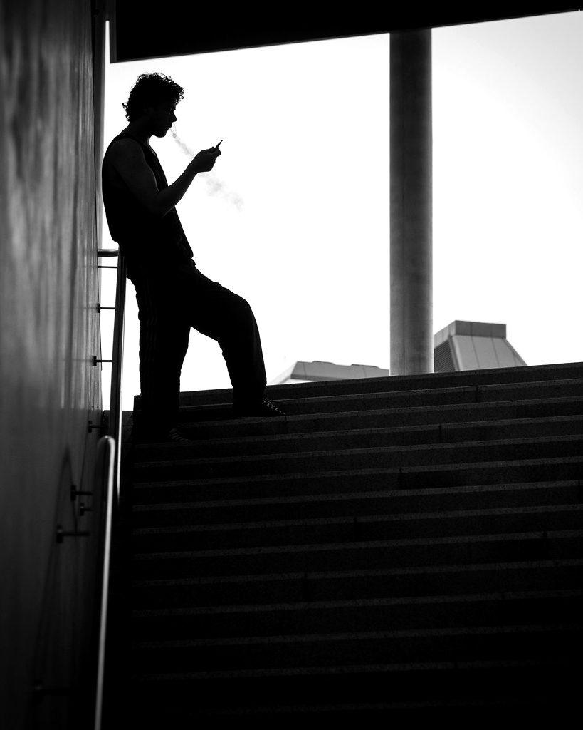 Silhouette of a figure on concrete stairs against a bright window